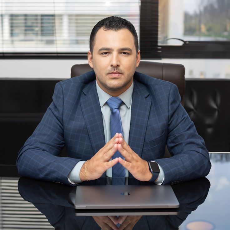 Prompt 17 — Professional executive seated behind an office desk, projecting aut...